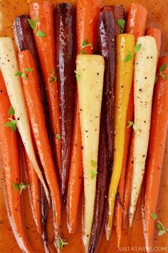 carrots and other vegetables are arranged on a cutting board