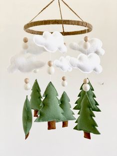 a mobile with trees and clouds hanging from it