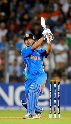 a man in blue uniform playing a game of cricket