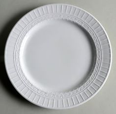 a white plate sitting on top of a gray countertop next to a knife and fork