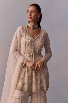 Off white sheer high-low cape with embroidered floral vine motifs, embellished by beads and crystals. Comes with inner padded bustier, dupatta and tiered sharara. - Aza Fashions Off White Floor-length Sharara With Intricate Embroidery, Luxury Embroidered Cream Sharara, Luxury Cream Embroidered Sharara, Beige Fitted Sharara With Intricate Embroidery, Floor-length Cream Sharara With Cutdana Details, Sharara Set, White Blouse, Floral Vine, Embroidered Silk