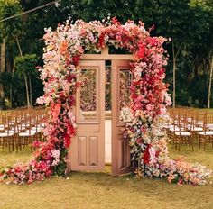 an outdoor ceremony area with flowers on the doors