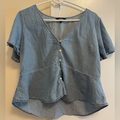 Like New Never Worn Light Blue Shirt With Buttons And Ruffle Short Sleeves. Blue Cotton V-neck Shirt, Casual Light Wash V-neck Top, Blue V-neck Shirt For Summer, Light Blue V-neck Summer Shirt, Trendy Light Blue V-neck Blouse, Trendy Denim V-neck Top, Trendy V-neck Denim Top For Summer, Medium Wash Denim V-neck Top, Light Blue Casual V-neck Shirt