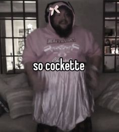 a man wearing a hoodie standing in front of a couch with the words so cockette on it