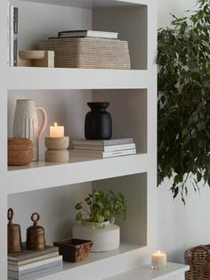 the shelves are filled with books and candles