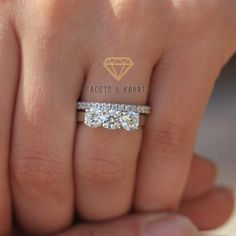 a woman's hand with two diamond rings on it