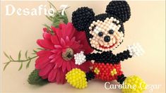 the beaded mickey mouse is holding a flower