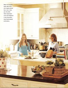 two women standing in a kitchen preparing food