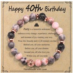 a happy birthday card with a bracelet made out of pink and black marbles on it