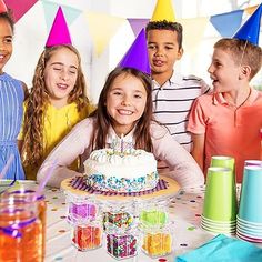 a group of children standing around a birthday cake