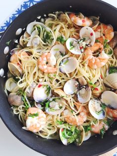 pasta with shrimp, clams and scallops in a skillet on a table