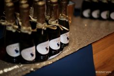 several bottles of wine are lined up on a table with gold ribbon around the edges