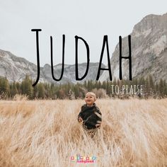 a young boy sitting in tall grass with the words judah above him