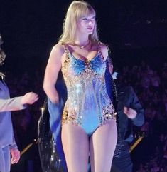 a woman in a bodysuit standing on stage