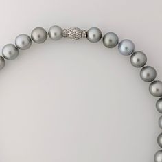 Experience the timeless elegance, crafted with exceptional quality and beauty. The necklace features lustrous Tahitian pearls of various sizes, ranging from 11 to 15 mm, and is finished with an 18K Rhodium-plated white gold and diamond clasp that adds a touch of luxury to the piece. The clasp contains 56 round brilliant cut diamonds (NC/SI) with a total weight of 1.23ct. The pearls showcase a silvery gray color pearls that exudes sophistication and refinement, with a uniformity that creates a harmonious appearance. Each pearl is carefully selected for its exceptional quality and luster, with a high shine and round shape that enhance the necklace's overall elegance. The necklace's length of 18.5 inches makes it versatile, pairing effortlessly with most necklines, and the weight of 112.1 gra Luxury Akoya Pearl Necklace With Sterling Silver Clasp, Luxury Tahitian Pearl Jewelry With Diamond Accents, Classic Round Tahitian Pearl Necklace, Tahitian Pearl Round Beads Formal Necklace, Luxury Tahitian Pearl Round Bead Necklace, Formal Tahitian Pearl Necklaces With Round Beads, Luxury Pearl Necklace With Sterling Silver Clasp, Formal Tahitian Pearl Round Bead Necklaces, Classic Tahitian Pearl Necklace For Anniversary