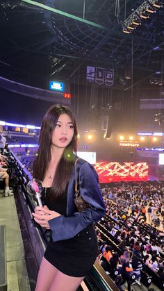 a beautiful young woman standing in front of a crowd