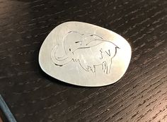 an elephant engraved on a metal disc sitting on a table