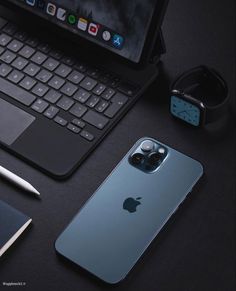 an apple phone sitting on top of a desk next to a laptop computer and pen