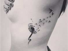 a woman's stomach with a dandelion tattoo on it