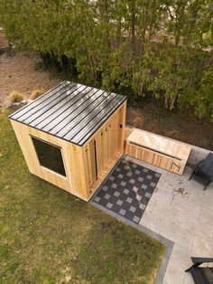 an aerial view of a small wooden structure in the middle of a yard with black and white checkered tiles