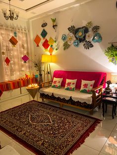 a living room filled with lots of furniture next to a wall covered in hanging decorations