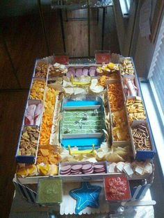 a football stadium shaped food tray with snacks on it, including crackers and dips