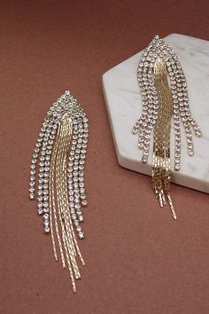 Rock a slithery sleek statement look wearing this pair of earrings! The gold-tone multi snake chain with multi rhinestone drop earrings. DIMENSION length: 4.5" width: 1" earring back: Post metal finish: Gold Plating Gold-tone Crystal Earrings For Party, Glamorous Gold Plated Crystal Earrings For Party, Glamorous Gold Jewelry With Rhinestone Fringe, Glamorous Gold Rhinestone Fringe Jewelry, Gold Chain Metal Earrings For Party, Gold Rhinestone Fringe Metal Jewelry, Gold Chain Earrings For Parties, Trendy Gold Metal Crystal Earrings, Gold Metal Jewelry With Rhinestone Fringe