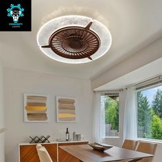 a dining room table and chairs in front of a window with a fan on the ceiling