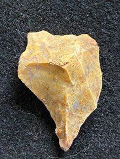 a yellow rock sitting on top of a black carpet