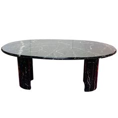 an oval marble table with black legs on a white background in the style of art deco