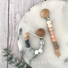 three wooden bead necklaces on a marble platter