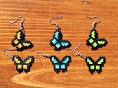 six pieces of beaded earrings sitting on top of a wooden table