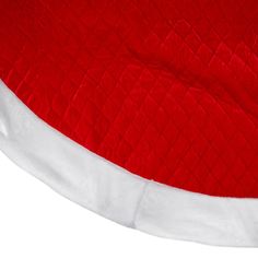 a red and white santa hat on top of a table cloth covered with a blanket