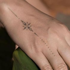 a person's hand with a small tattoo on it