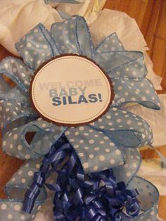 a blue and white polka dot wreath with the words baby silas on it's side