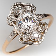 an antique style diamond ring with two tone gold band and diamonds in the center, on a white background