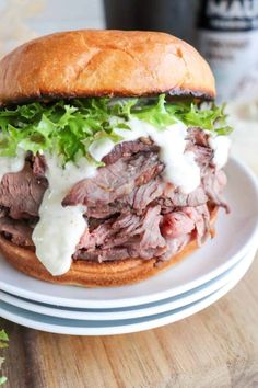 a roast beef sandwich with white sauce and lettuce