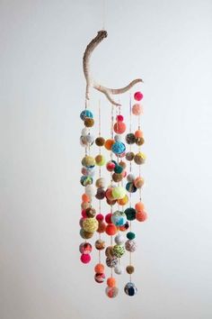 a wind chime hanging from the ceiling with multi colored balls and beads on it