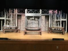 an empty stage set with chairs and bars on the seats are made out of wood