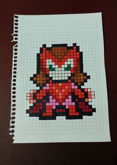 an image of a pixel art piece on a paper with pen and scissors next to it