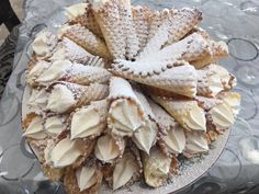 a cake that is sitting on top of a glass platter covered in powdered sugar