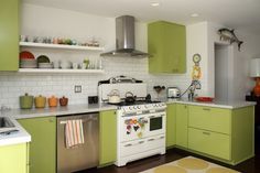 a kitchen with green cabinets and white appliances