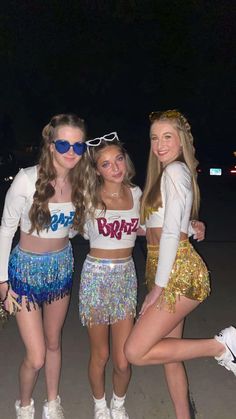 three young women in sequin skirts posing for the camera