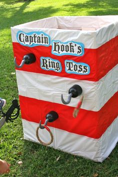 a box that is made to look like a ring tosser in the grass with two handles on each side