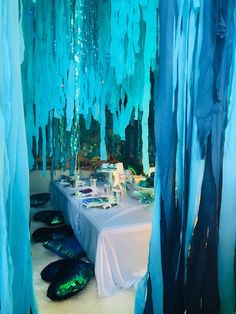 the table is set up with blue streamers hanging from the ceiling