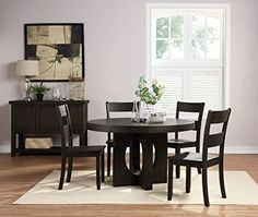 a dining room table with four chairs and a vase on top of it in front of a window