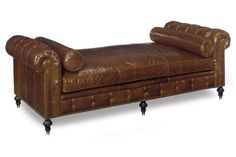 a brown leather chaise lounger on casteors