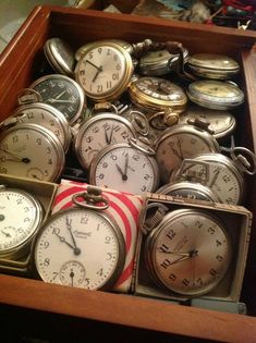 an open drawer filled with lots of different types of clocks