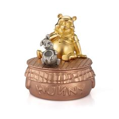 a small statue of winnie the pooh and her piggy on top of a pot