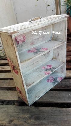 an old wooden shelf with flowers painted on it